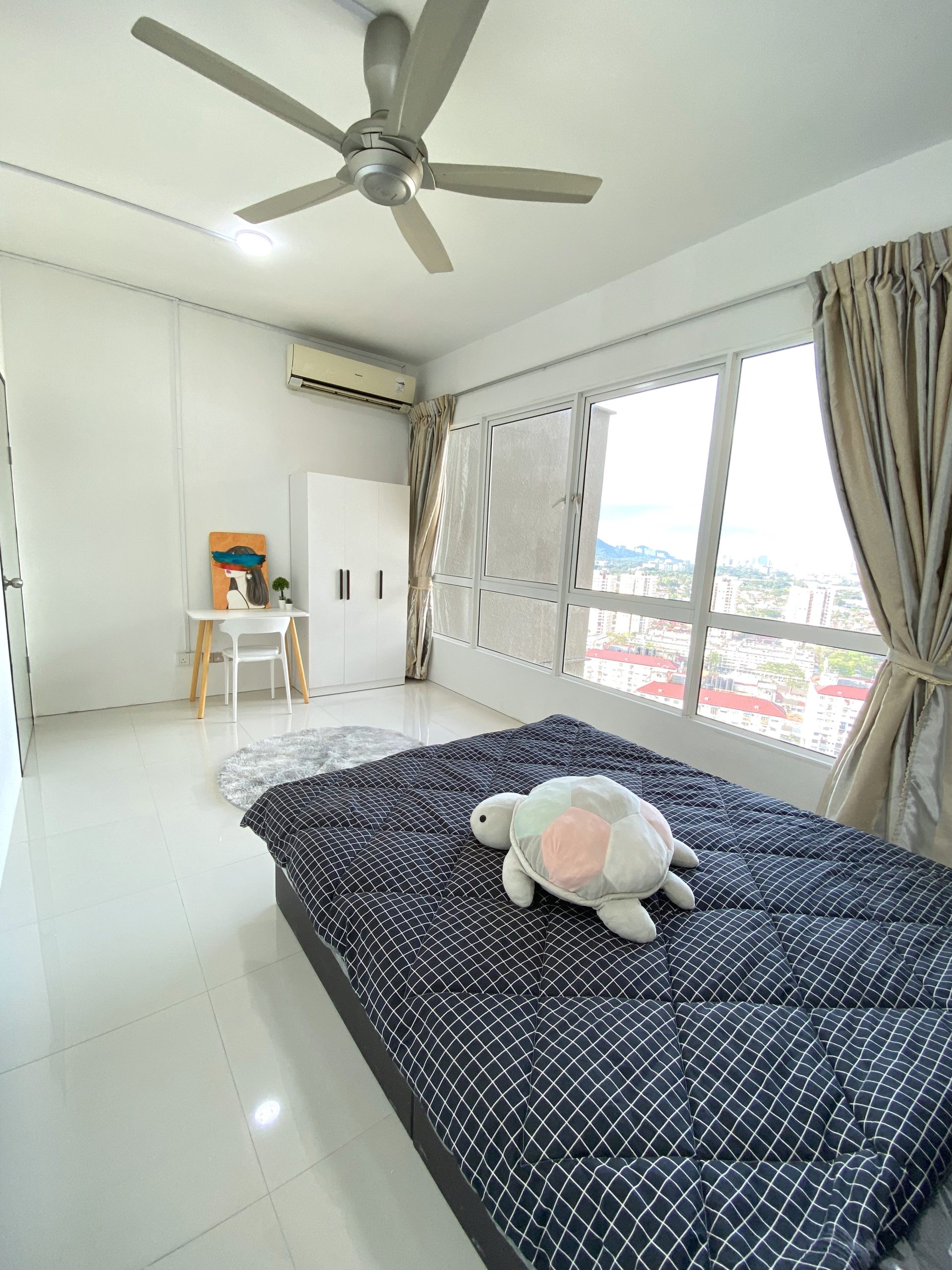 Medium room for rent in Jelutong with bed, desk, wardrobe, and ceiling fan